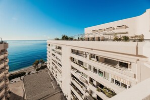 Ett hotell med flera våningar och balkonger med utsikt över en strand och havet.