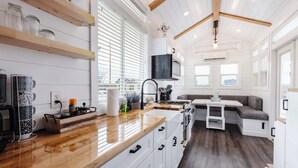 Een moderne keuken met witte kasten, een houten aanrechtblad en een ingebouwde kookplaat.