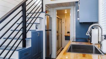 A modern kitchen with a wooden countertop, stainless steel appliances, and a blue cabinetry.