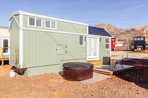 Un bâtiment compact, de plain-pied, doté d’un toit plat, d’un petit espace porche et d’un jacuzzi.