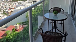 A balcony with a view of a coastal cityscape, including buildings and a flag. - Apartment with a beautiful view of the Bay (Acapulco de Juárez)