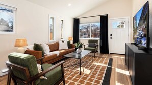 A modern living room with a sofa, armchairs, a coffee table, and a television. - Arvada Retreat | Garage | Near Olde Town+Red Rocks (Arvada)