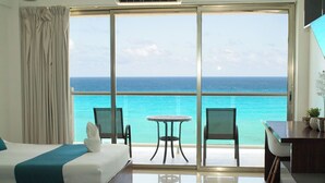 Une chambre d’hôtel avec un grand balcon, un lit, une table et des chaises.