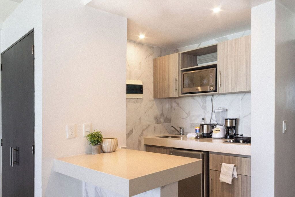Una cocina moderna con salpicadero de mármol, armarios de madera y electrodomésticos de acero inoxidable.