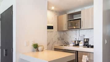 Una cocina moderna con salpicadero de mármol, armarios de madera y electrodomésticos de acero inoxidable.