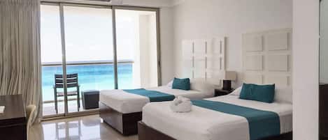 Quarto de hotel com duas camas, uma escrivaninha e uma cadeira.