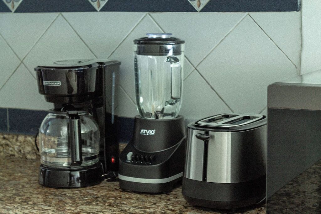 A kitchen counter with a coffee maker, a blender, and a toaster.