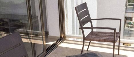 Un balcon agrémenté de meubles en osier, notamment une chaise et une petite table.