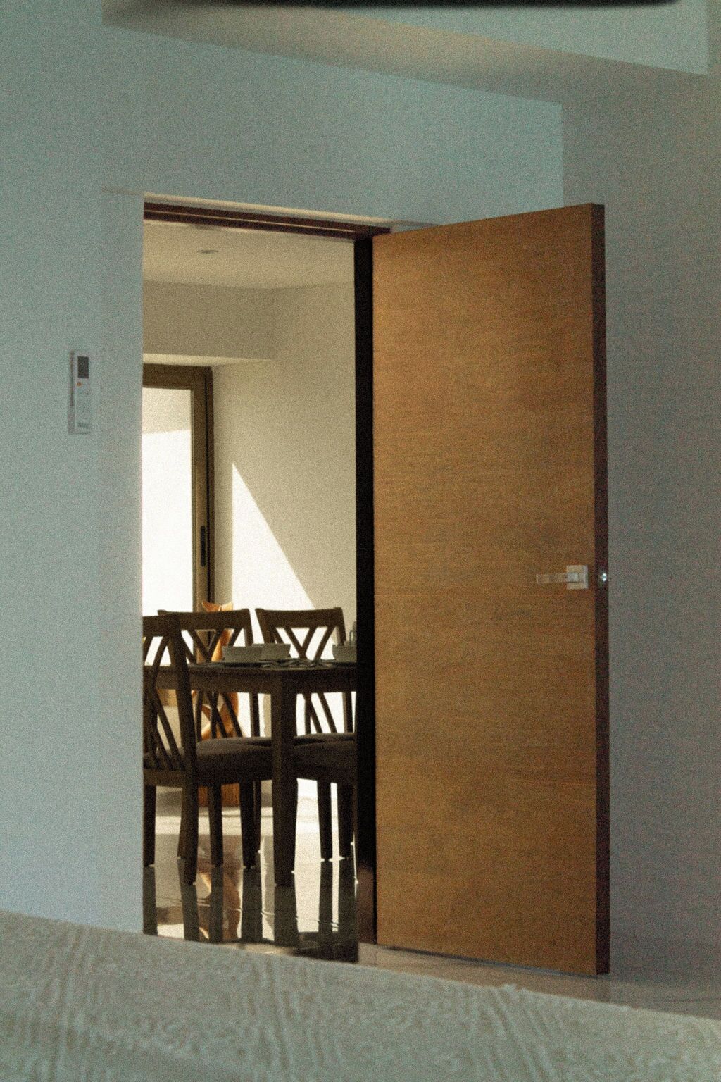 Huone, jossa on sänky, puuovi sekä ruokailutila, jossa on pöytä ja tuolit.