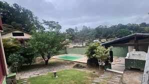 Ein Garten mit Swimmingpool, Steintreppe und Rasenfläche.