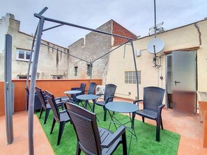 An outdoor patio with tables and chairs, a pergola, and a satellite dish. - Jacuzzi Room (Perpignan)