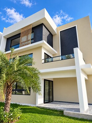 A modern two-story building with a flat roof, large windows, and a balcony. - A Peaceful Retirement in Punta Cana (Punta Cana)