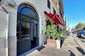 Un bâtiment doté d’une grande entrée en arc de cercle, d’un auvent rouge et d’une enseigne portant le numéro « 37 ».
