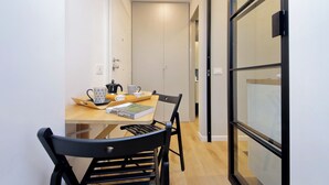 A narrow hallway with a wooden table and chairs, a book, and a mug. - 4BNB - Marmorata Urban Nest (Rome)