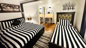 Une chambre d’hôtel avec deux lits, un coin repas et une cheminée.