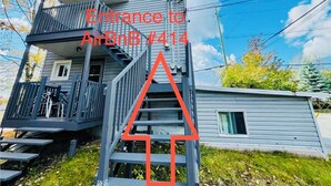 Un immeuble de deux étages doté d’un balcon à l’étage supérieur et d’un escalier menant à l’entrée.