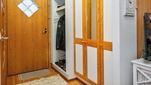 Ein Flur mit Holztüren, einem Kleiderständer und einer Uhr an der Wand.