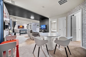A modern living room with a round marble table, white chairs, a sofa, and a flat-screen TV. - 10BR house with private pool in clermont (Clermont)
