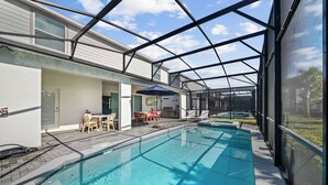 Piscina com área de estar coberta, mobiliário de exterior e vista para a paisagem circundante.