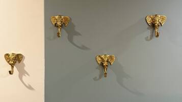 Un muro con quattro ganci a forma di elefante dorati.