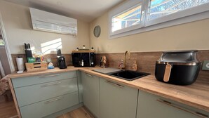 A modern kitchen with a sink, a coffee maker, a microwave, and a kettle. - 15 minutes from Futuroscope! Lovely two-bedroom house ideal for families (Naintré)