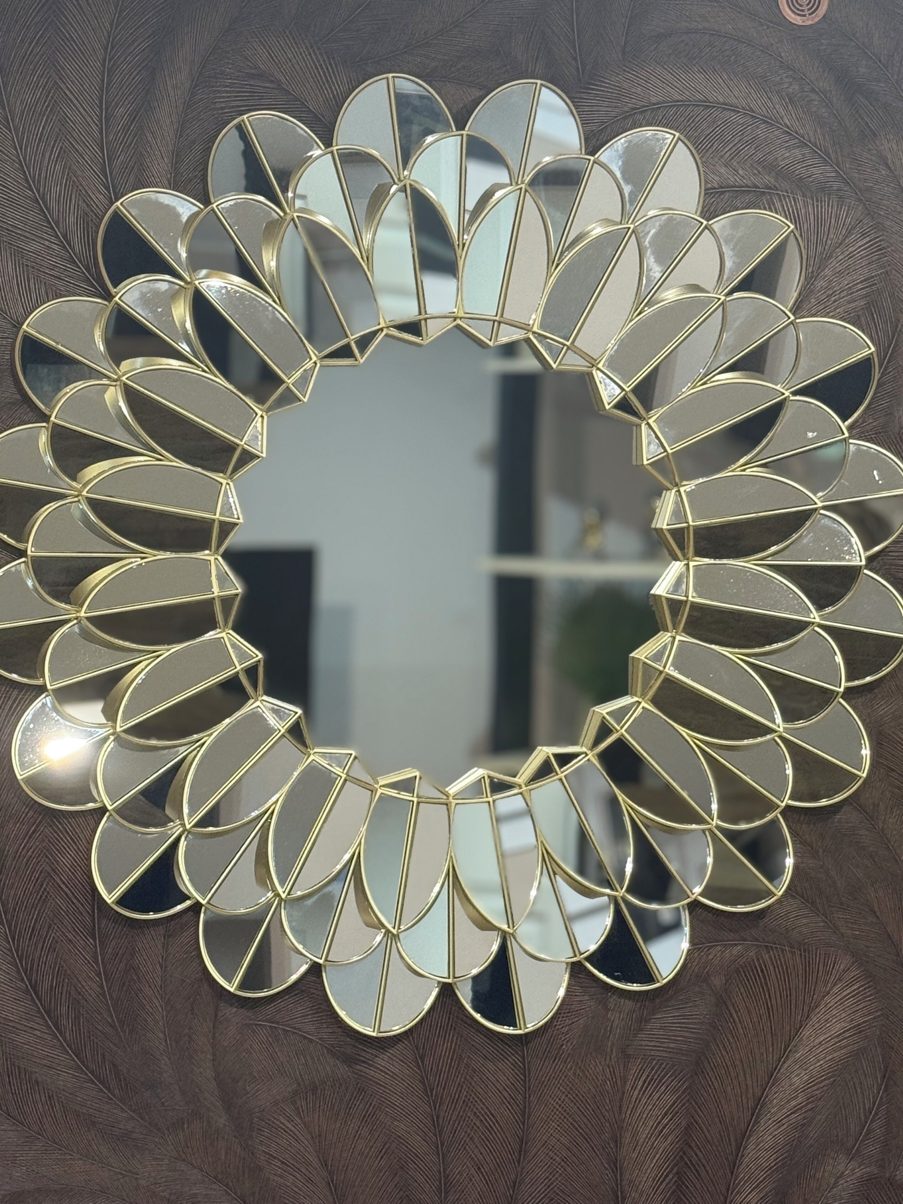 Pyöreä peili, jonka reunassa on aaltoileva koristekuvio.