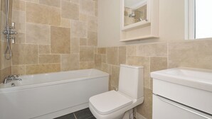 A bathroom with a bathtub, toilet, and sink, all in white. - 4 Polgrain Turning (Bodmin)