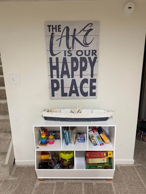 Eine Wand mit einem motivierenden Zitat, eine weiße Ablage mit verschiedenen Gegenständen und eine Whiteboard-Tafel.