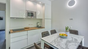 A modern kitchen with white cabinets, a built-in microwave, and a wooden countertop. - Mobilehome in Porlezza am Luganersee (Porlezza)
