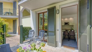 An open patio with chairs, a dining table, and a flower arrangement. - Mobilehome in Porlezza am Luganersee (Porlezza)