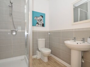 Une salle de bain moderne équipée d’une douche, de toilettes et d’un lavabo.