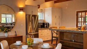 A modern kitchen with a central island, white cabinetry, and a stainless steel refrigerator. - 10 minutes to Sequoia Park Entrance/Hot Tub/Fire Pit/Pet Friendly/Mountain Views (Three Rivers)