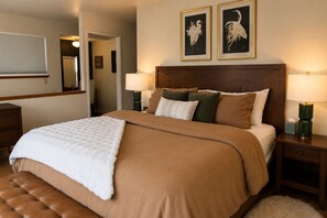 A neatly made bed with a brown bedspread and white throw, flanked by two nightstands with lamps, in a room with a wooden headboard and framed wall art. - 10 minutes to Sequoia Park Entrance/Hot Tub/Fire Pit/Pet Friendly/Mountain Views (Three Rivers)