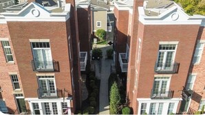 Un immeuble résidentiel à plusieurs étages, doté de façades en briques, de balcons et d’une cour intérieure.