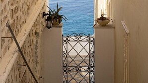 A narrow alleyway with a view of the sea and a distant island. - Laeticia - Seven Bedroom Villa, Sleeps 14 (Finikas)