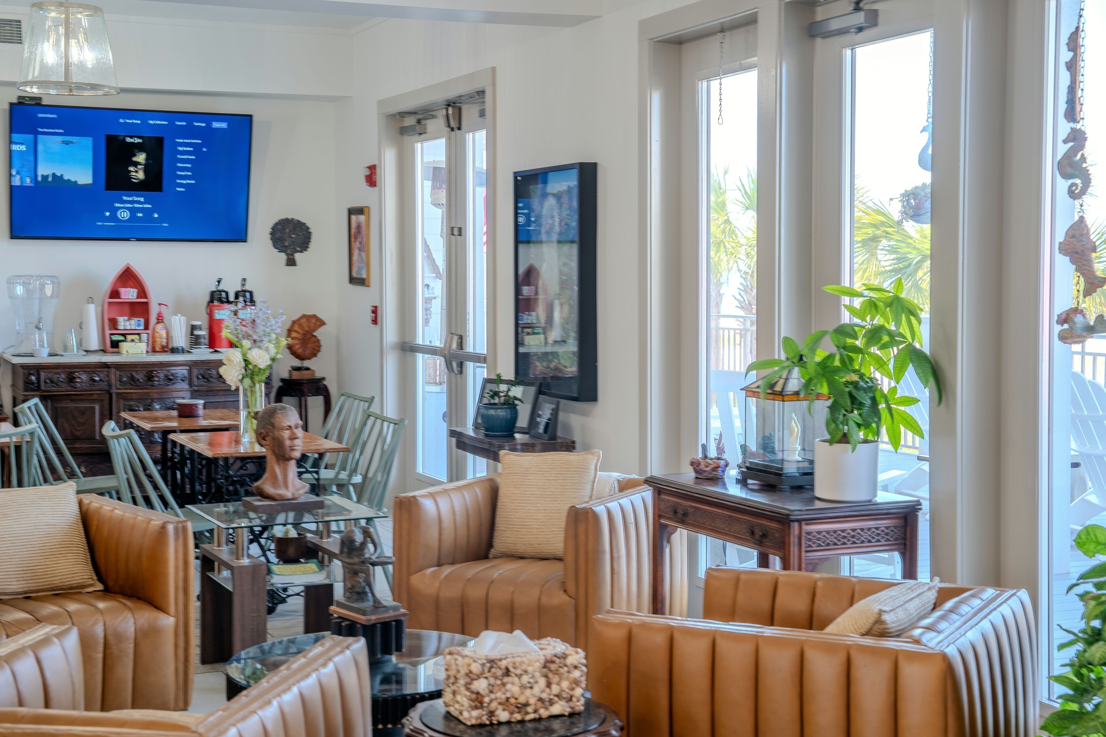 Un saló amb sofàs de cuir, una taula de cafè de vidre, un televisor de pantalla plana i una planta en test.