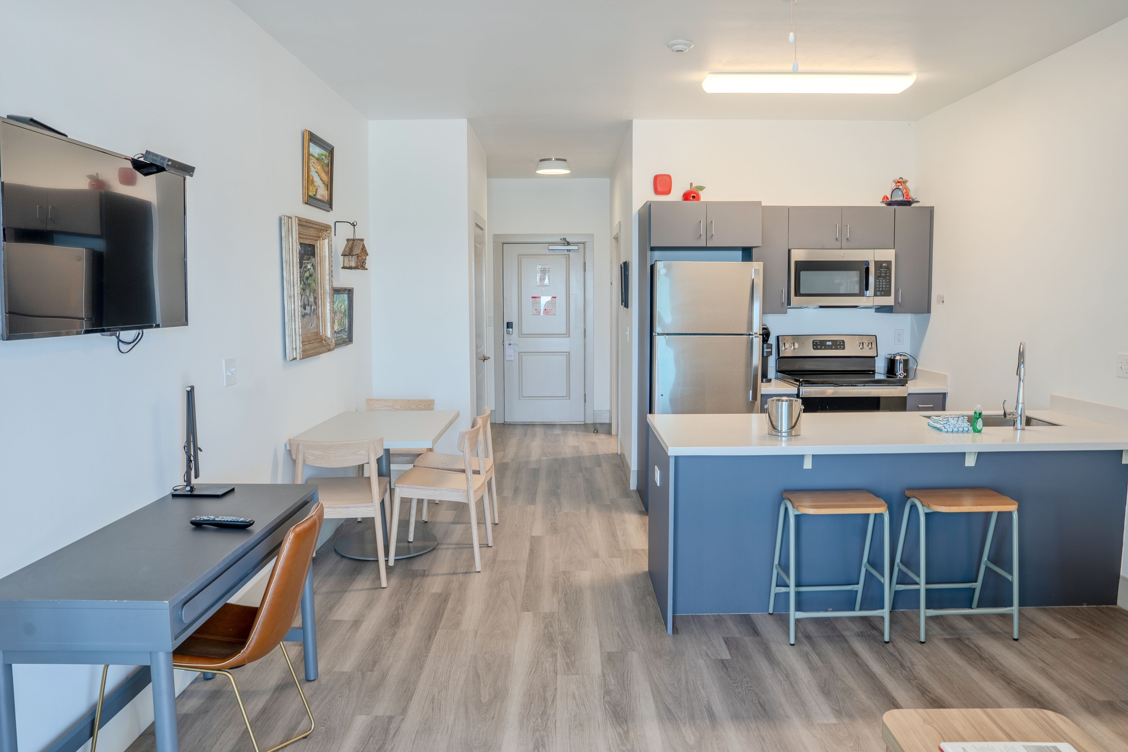 Une cuisine moderne dotée d’un îlot central, de tabourets de bar, d’un four à micro-ondes et d’un réfrigérateur.
