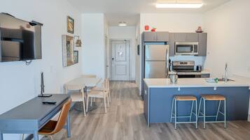 Une cuisine moderne dotée d’un îlot central, de tabourets de bar, d’un four à micro-ondes et d’un réfrigérateur.