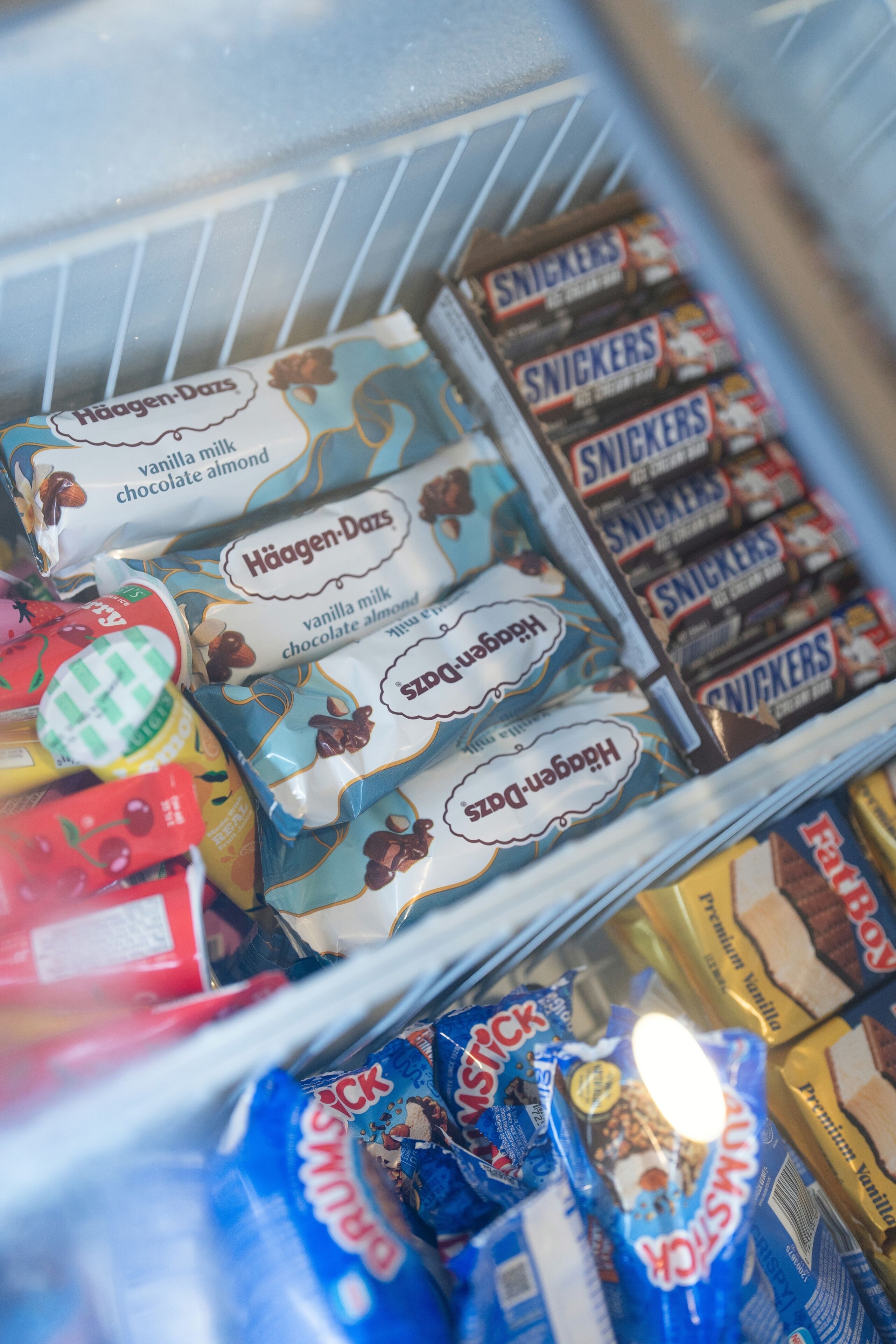 A refrigerated display case with various packaged snacks, including Häagen-Dazs and Snickers.