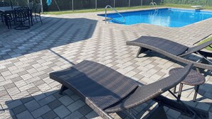 Un espace aménagé au bord de la piscine, avec des fauteuils de relaxation en osier et une piscine.