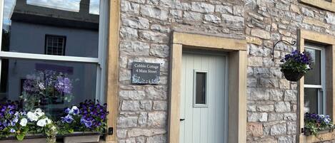 A stone building with a sign reading 'Cobble Cottage 4 Main Street.'