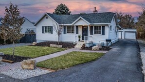 A two-story house with a front porch, a garage, and a driveway. - Millcreek Basecamp - Pet friendly and Convenient! (Salt Lake City)