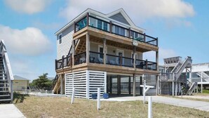 Et toetagers hus med en balkon på øvre plan, en trappe op til anden sal og et terrassedæk.