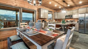 Una cocina moderna con armarios de madera, electrodomésticos de acero inoxidable y un comedor con una mesa y sillas de madera.