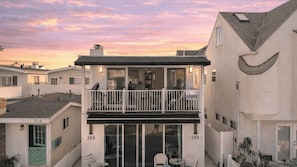 A residential building with a balcony, a visible door, and a number '210' on the facade.