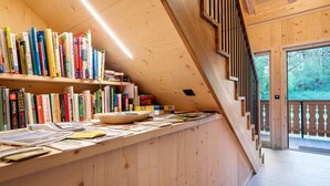Un interior de madera con estanterías, un escritorio con papeles y una escalera.