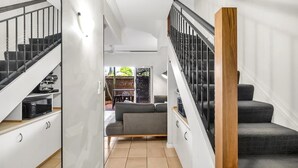 Un interno moderno con una scala, un divano e un'area pranzo.