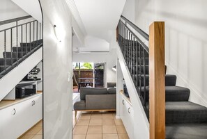 Ein modernes Interieur mit Treppe, einer Couch und einem Essbereich.
