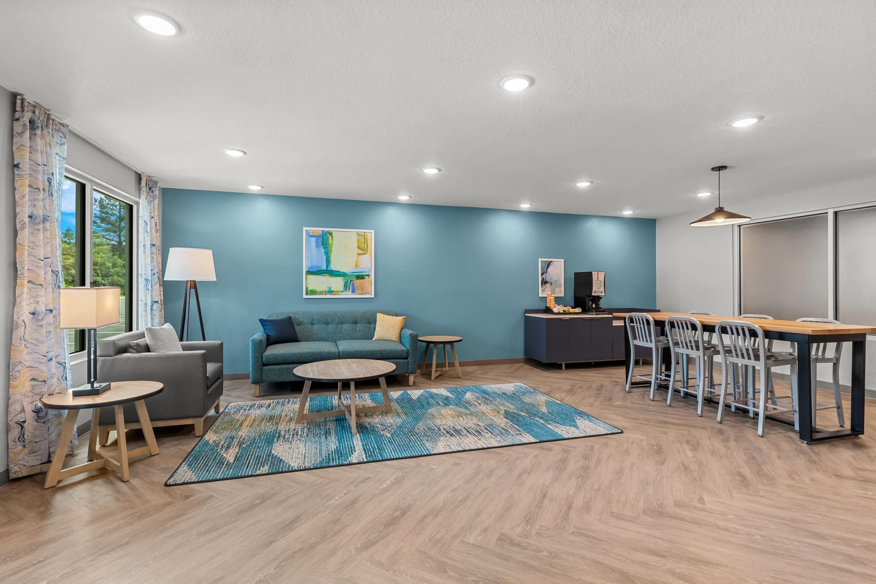 A modern living room with a sofa, coffee table, and dining area with chairs.