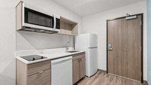 Uma cozinha compacta com micro-ondas, lava-louças e frigorífico.